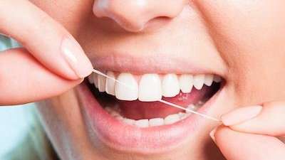 A woman flossing her teeth 