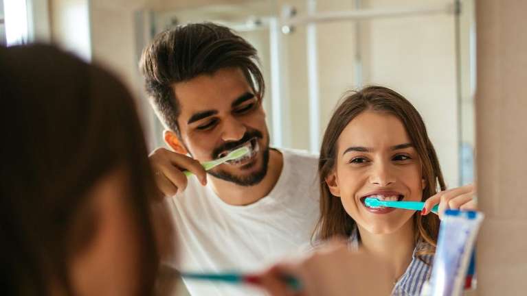 A couple brushing their teeth together | gum disease Prairieville
